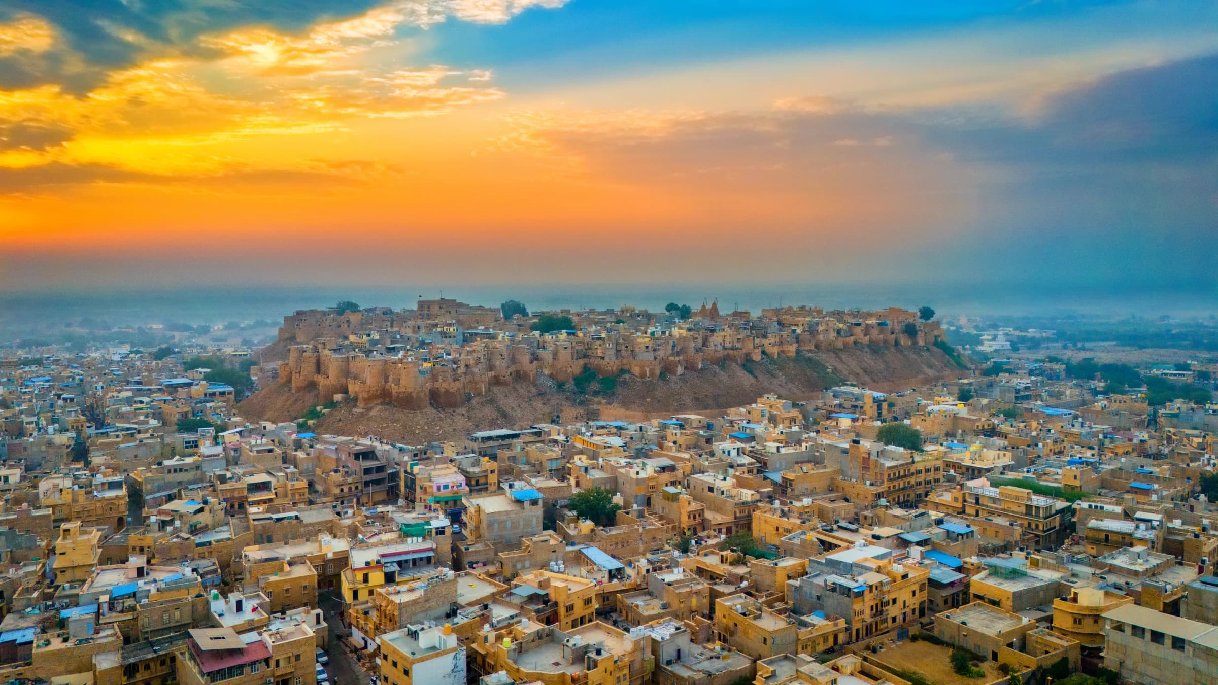 Jaisalmer Fort rising above the golden sandstone houses of the old city at sunrise